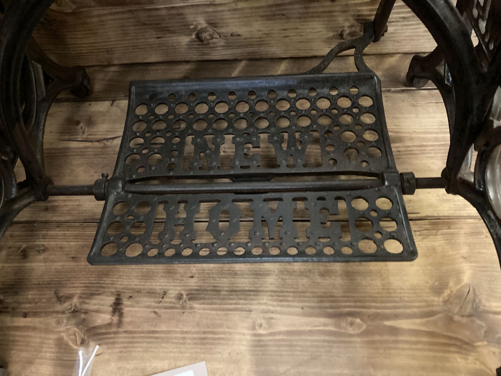 A Victorian Newhome cast iron treadle sewing machine base now as a glass top occasional table, width 75cm, depth 45cm, height 72cm